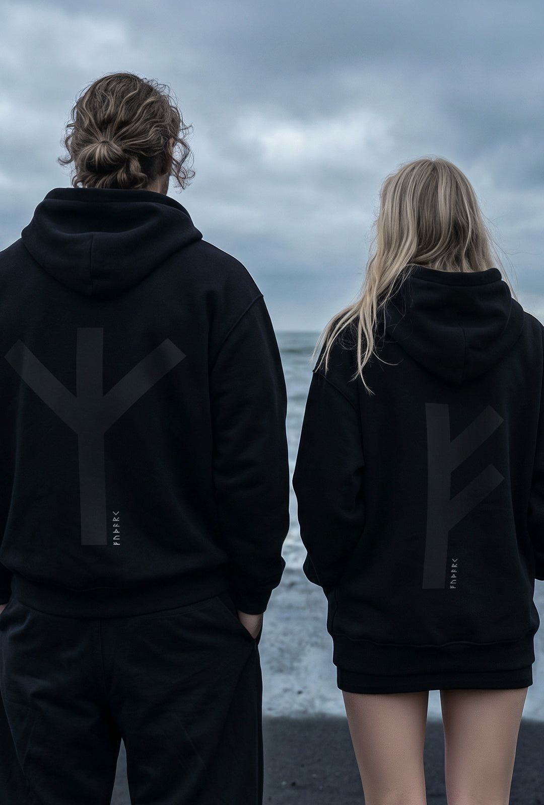 Black minimalist hoodie featuring a large Thurisaz rune printed on the back, symbolizing protection and raw force. Clean silhouette with relaxed fit, matte fabric texture, and subtle streetwear aesthetic, photographed from a partial rear angle with soft, moody lighting.
