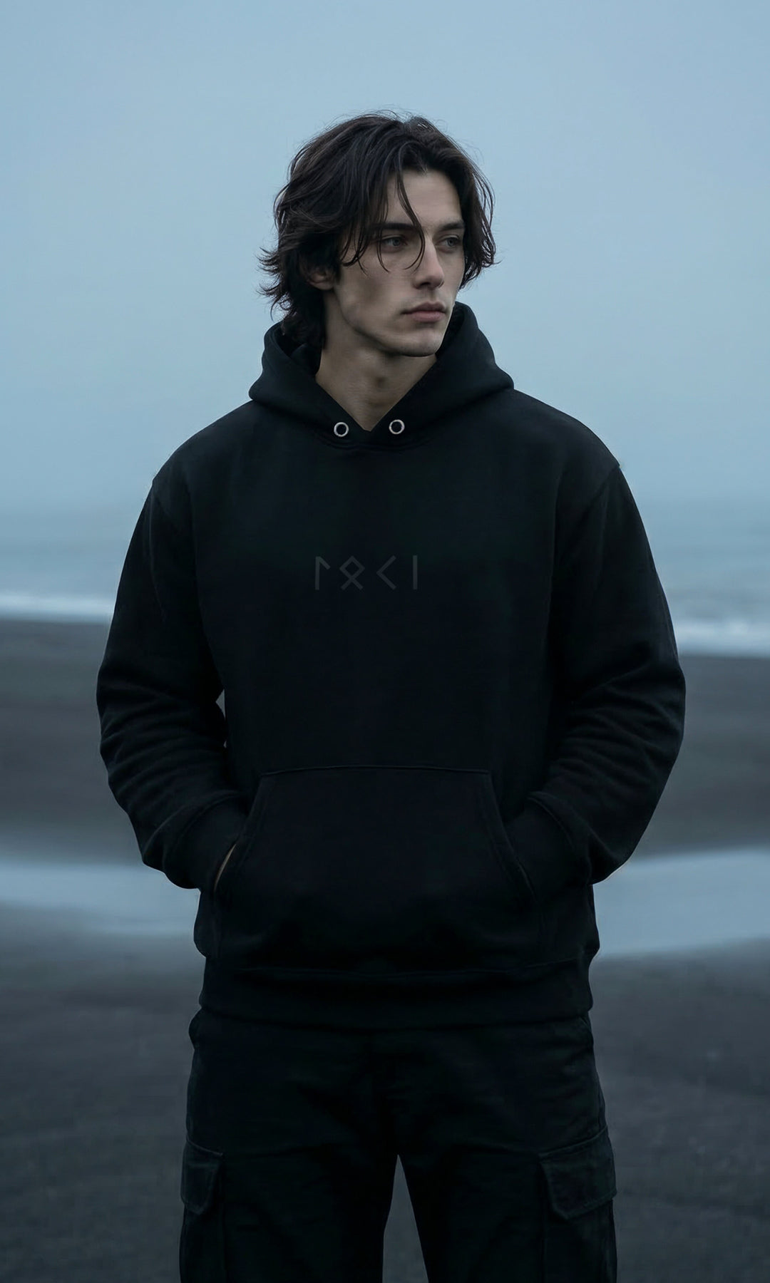 Black minimalist Loki hoodie featuring the name “Loki” spelled out in Elder Futhark runes. Sleek Norse-inspired design with subtle runic detailing, pullover style, adjustable hood, and kangaroo pocket.